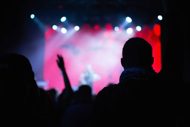 Silhuetas de uma multidão de concertos em frente a um palco iluminado em uma boate
. - Foto, Imagem