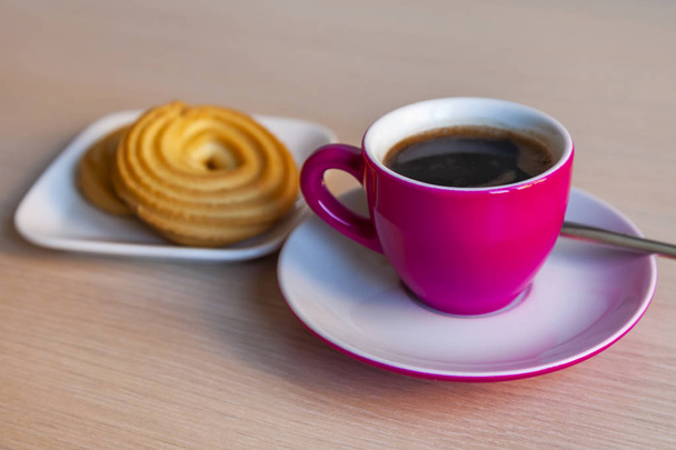 Espresso coffee in a bright pink porcelain cup and cookies on a saucer - Photo, Image