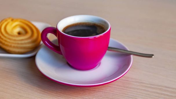 Espresso coffee in a bright pink porcelain cup and cookies on a saucer - Foto, imagen