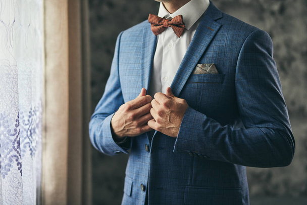 Uomo d'affari indossa una giacca, mani maschili primo piano, sposo si prepara al mattino prima della cerimonia di matrimonio - Foto, immagini