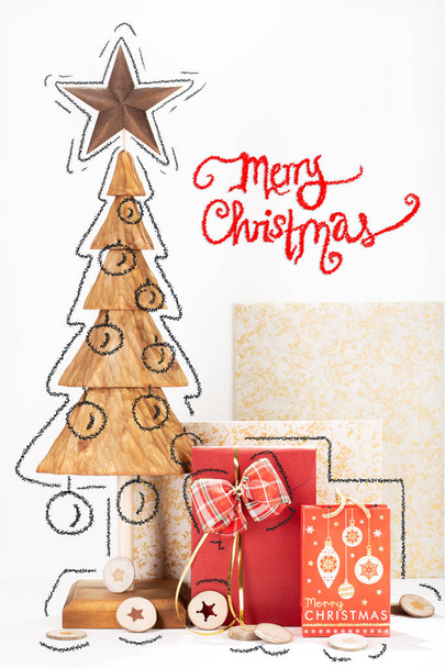 Biglietto natalizio con scultura in legno di pino e scatola regalo. Biglietto natalizio tradizionale con testo natalizio allegro
 - Foto, immagini