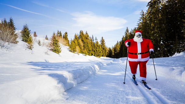 Santa Claus con trajes de Navidad con esquí nórdico clásico en invierno nevado estación de esquí de montaña paisaje en día soleado, Año Nuevo o Navidad está llegando
. - Foto, imagen