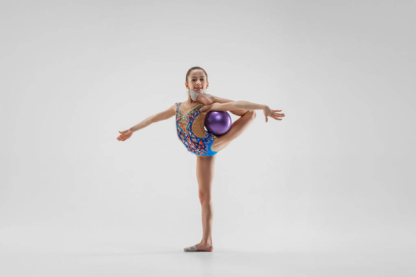 The teenager girl doing gymnastics exercises isolated on white background - Foto, imagen