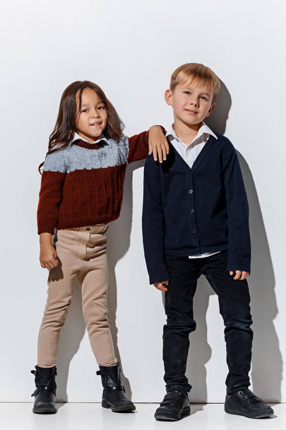 The portrait of cute little boy and girl in stylish jeans clothes looking at camera at studio - Valokuva, kuva