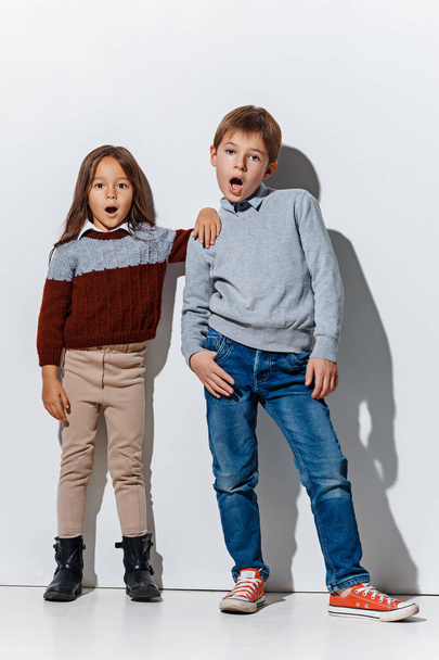 The portrait of cute little boy and girl in stylish jeans clothes looking at camera at studio - Photo, Image