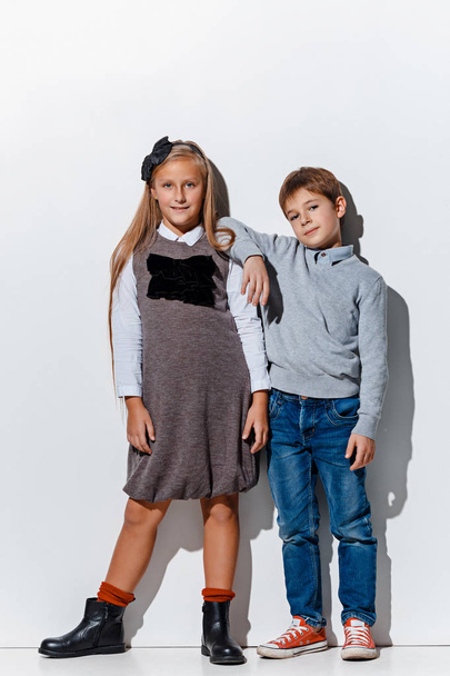 The portrait of cute little boy and girl in stylish jeans clothes looking at camera at studio - Foto, imagen