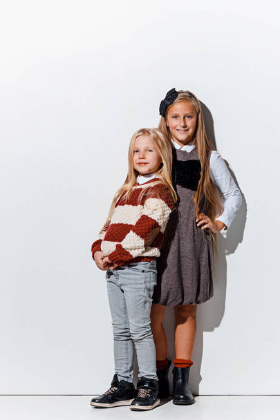 The portrait of cute little girls in stylish jeans clothes looking at camera at studio - Fotografie, Obrázek