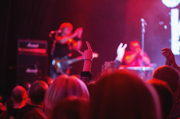 Силуэты концертной толпы перед освещенной сценой в ночном клубе
. - Фото, изображение