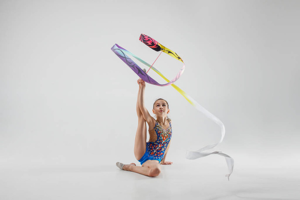 Het portret van mooie jonge brunette vrouw gymnast opleiding calilisthenics oefenen met lint - Foto, afbeelding
