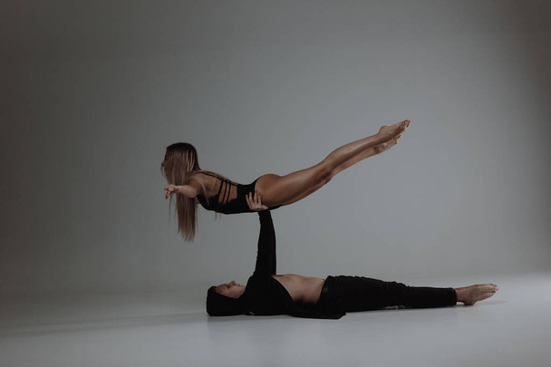 Two young modern ballet dancers posing over gray studio background - Foto, immagini