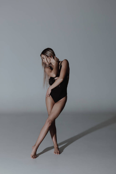 Contemporary style dancer woman posing on a studio grey background - Zdjęcie, obraz