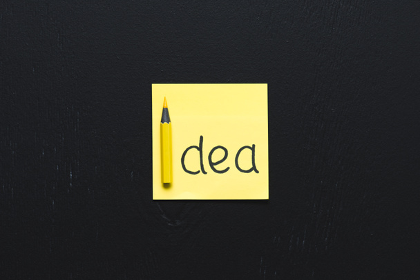 ylhäältä näkymä 'idea' sana kirjoitettu keltainen tahmea huomautus musta tausta, ideoita käsite
 - Valokuva, kuva