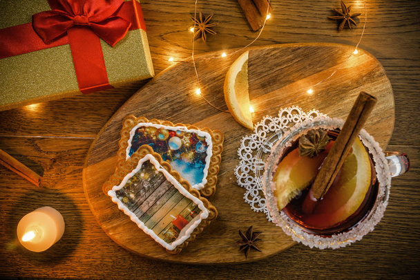 Boisson chaude traditionnelle de Noël - vin rouge chaud - aux épices, biscuits et fruits sur une table rustique en bois
. - Photo, image