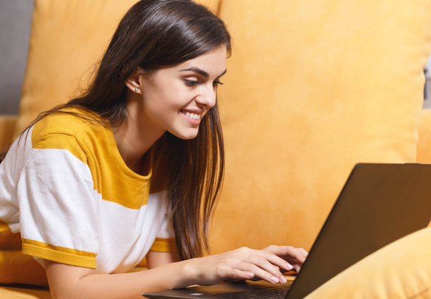Cheerful Girl Laying With Her Laptop - Foto, imagen