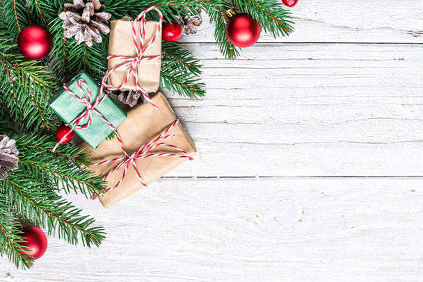 Vánoční dekorace s jedle, dárkové krabičky, bobule a šišky na bílém pozadí dřevěná kopie prostor pro váš text. pohled shora. plochý lay - Fotografie, Obrázek