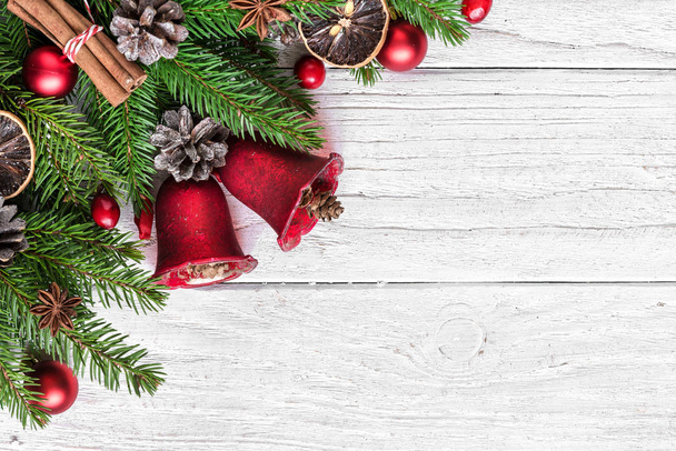Різдвяна святкова композиція з ялинкою, різдвяними дзвіночками, ягодами та сосновими шишками на білому дерев'яному фоні з місцем для тексту. вид зверху. плоский ліжко
 - Фото, зображення