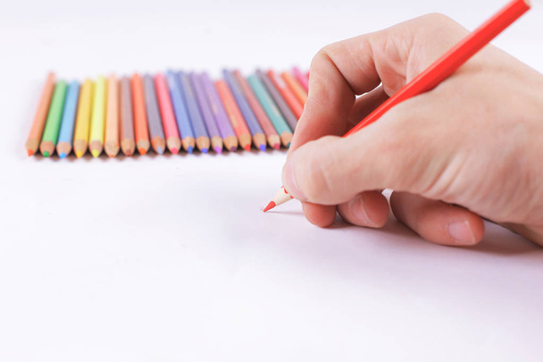 closeup.womans hand draws a red pencil on a white sheet of pap - Zdjęcie, obraz
