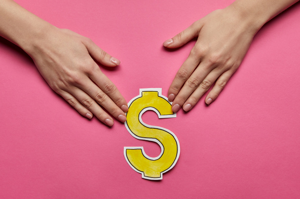 vista superior de las manos sosteniendo el signo del dólar sobre fondo rosa
 - Foto, Imagen
