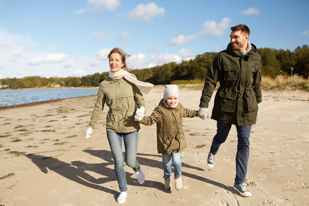 happy family running along autumn beach - Foto, immagini