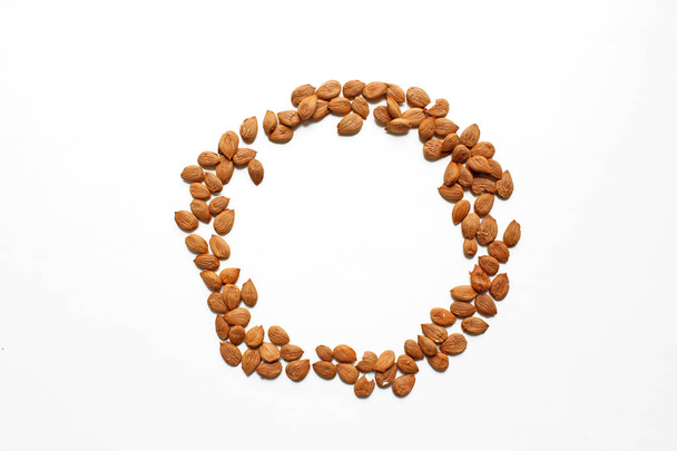round frame of  apricot pits on a white background - Foto, afbeelding