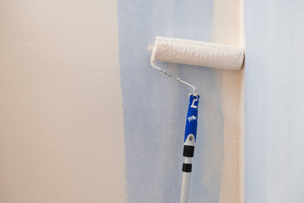 Person appplying paint on wall using roller brush. Home renovation concept. - Fotoğraf, Görsel
