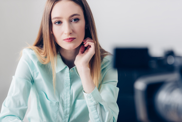 attrayant blogueur vidéo femme en turquoise chemise enregistrement vlog dans le bureau
 - Photo, image