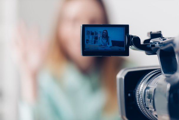 selective focus of female video blogger recording vlog in office, camera on foreground - Φωτογραφία, εικόνα