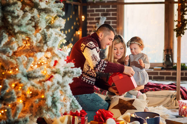 Happy family with a baby in a Christmas room. - Фото, зображення
