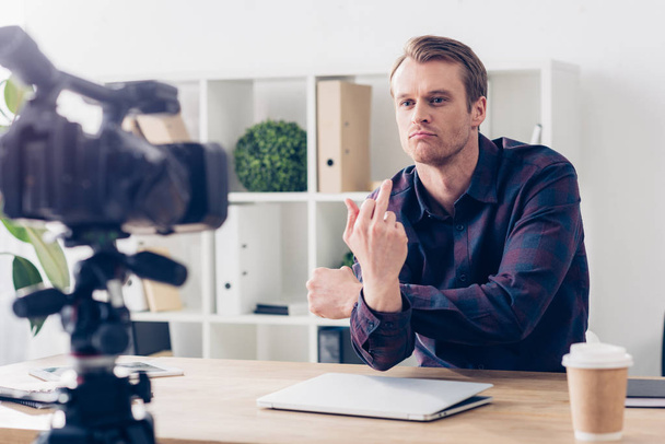 maschio video blogger registrazione vlog e mostrando dito medio in ufficio
 - Foto, immagini
