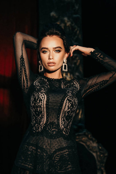 fashion interior photo of gorgeous sexy woman with dark hair in luxurious lace dress posing in theater interior - Zdjęcie, obraz