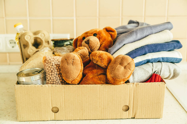 Donating concept - food, clothes, toys in cardboard - 写真・画像