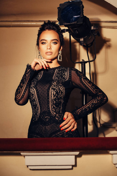 fashion interior photo of gorgeous sexy woman with dark hair in luxurious lace dress posing in theater interior - Foto, afbeelding