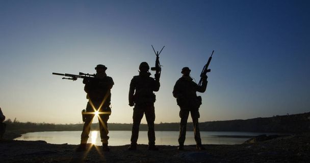 Τρεις στρατιώτες που ποζάρει με τα πυροβόλα όπλα - Φωτογραφία, εικόνα