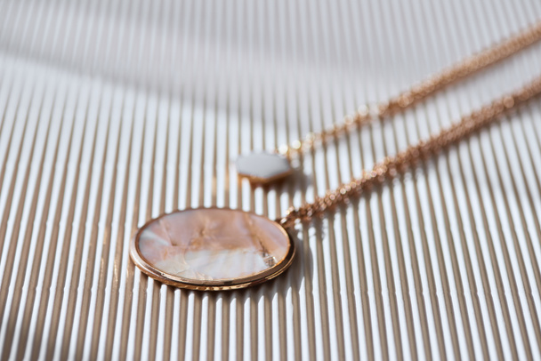 mooie luxe ronde medaillon met marmer op gestreepte wit oppervlak met zonlicht - Foto, afbeelding