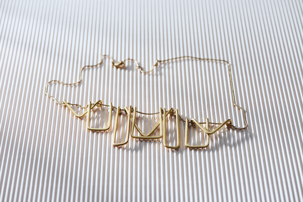 beautiful luxury necklace on striped white surface with sunlight - Φωτογραφία, εικόνα