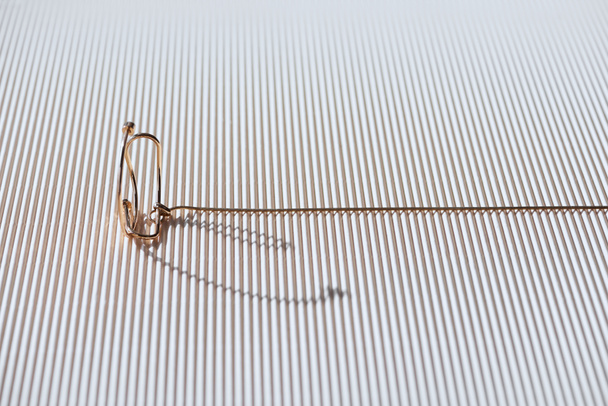 kaunis eleganssi kaulakoru raidallinen valkoinen pinta auringonvalolla
 - Valokuva, kuva