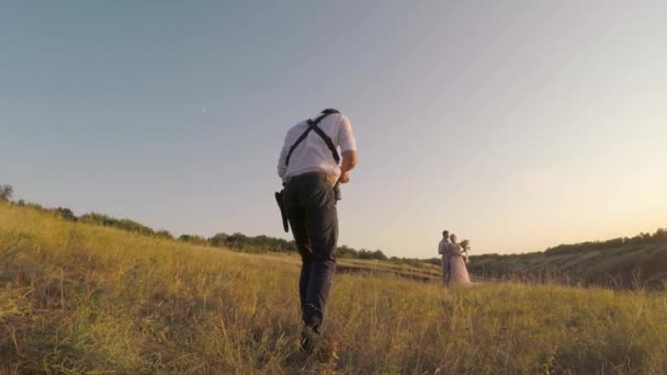 wedding photographer takes pictures of the bride and groom - Materiał filmowy, wideo