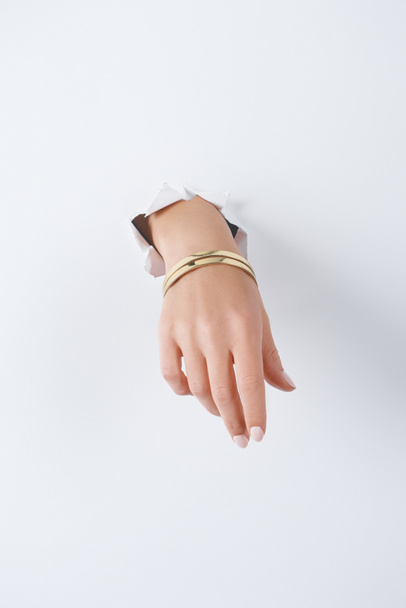 cropped image of woman holding hand with beautiful luxury bracelet through white paper - Foto, Bild