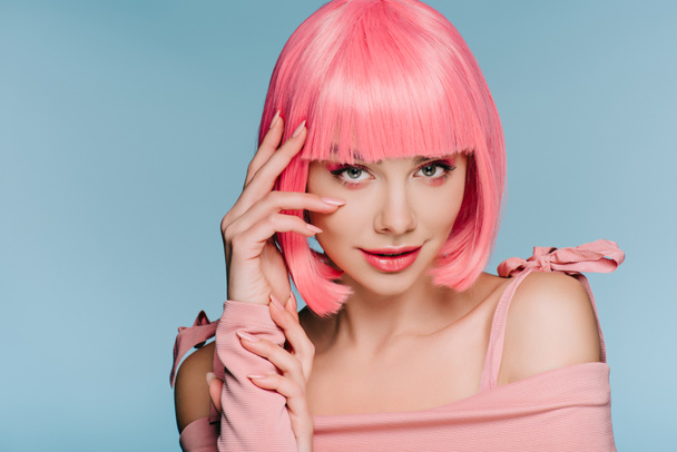 attractive fashionable girl posing in pink wig isolated on blue - Foto, Imagen