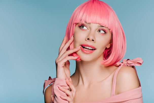 красивая мечтательная девушка позирует в розовом парике изолированы на синий
 - Фото, изображение