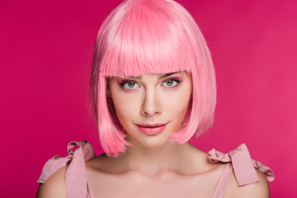 attractive stylish young woman posing in pink wig, isolated on pink - Photo, Image