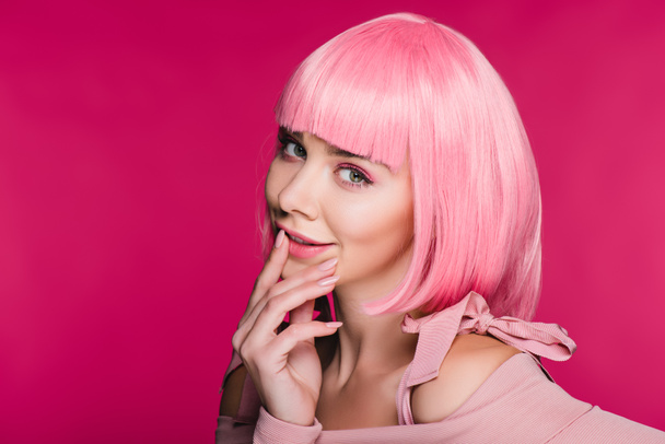 fashionable young woman posing in pink wig, isolated on pink - Photo, Image