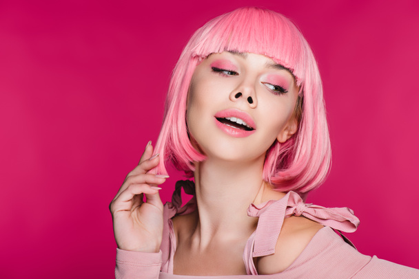 sinnlich stylisches Mädchen posiert in rosa Perücke, isoliert auf rosa - Foto, Bild