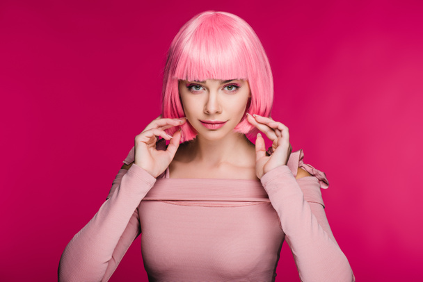 beautiful fashionable girl posing in pink wig for fashion shoot, isolated on pink - Photo, Image