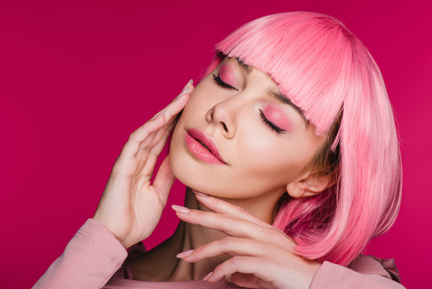tender girl in pink wig posing with closed eyes, isolated on pink - Fotó, kép