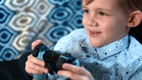 мальчик играет в видеоигру с джойстиком и демонстрирует много эмоций
 - Кадры, видео