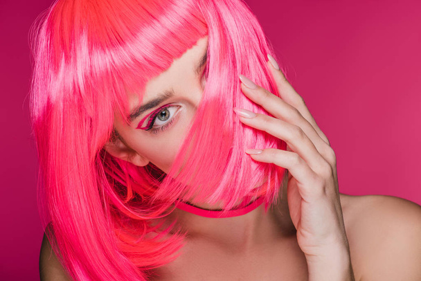 modelo atractivo de moda posando en peluca rosa neón, aislado en rosa
 - Foto, imagen