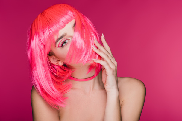 beautiful stylish model posing in neon pink wig, isolated on pink - Фото, зображення