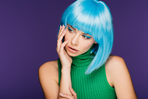 fashionable young woman posing in blue wig, isolated on purple - Photo, Image