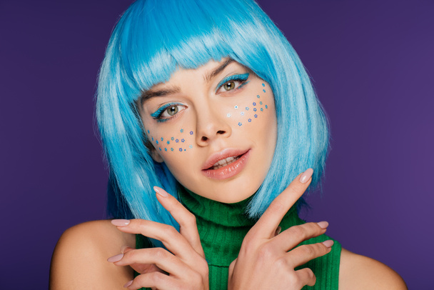 attractive glamor girl with blue wig and stars on face, isolated on purple - Фото, зображення